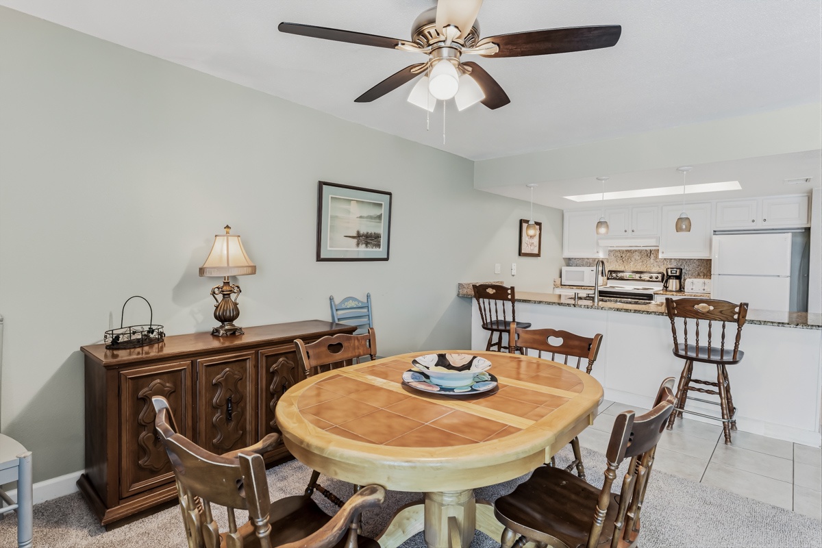 Gather around the inviting round dining table where meals and memories blend seamlessly. The open layout flows into a bright, fully equipped kitchen with modern appliances and plenty of counter space.