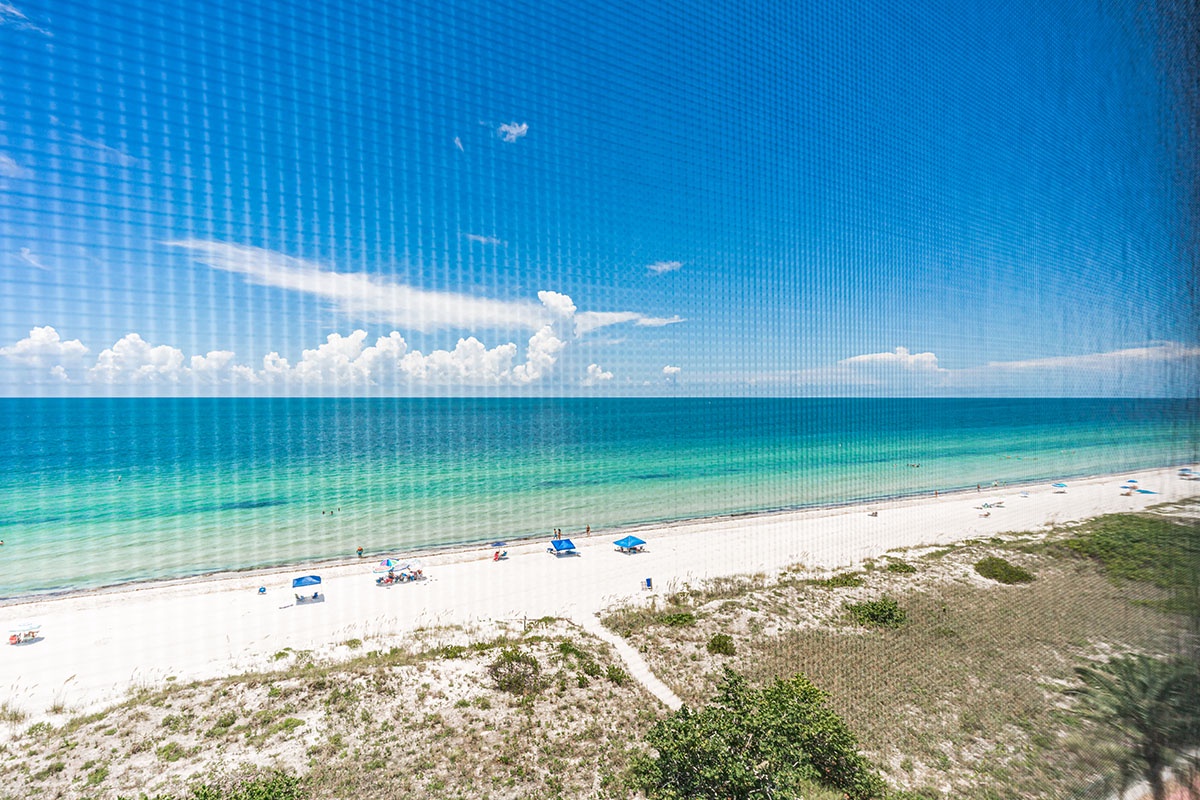 Pristine white sand beach meets crystal-clear turquoise waters under brilliant blue skies, creating the perfect tropical paradise.
