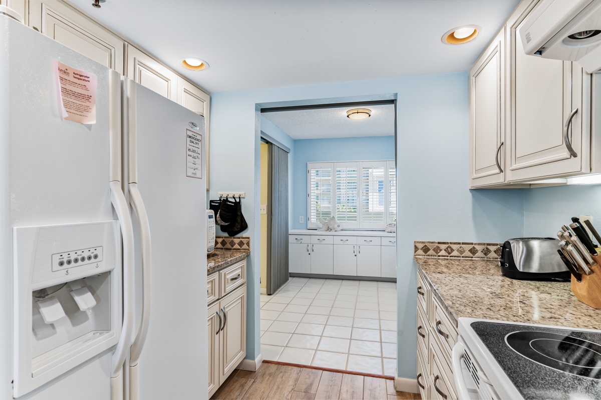 Your fully equipped kitchen features modern appliances and plenty of counter space, with soft blue walls creating a calm, inviting atmosphere for preparing meals during your stay.