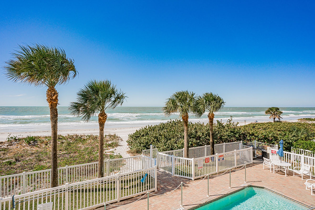 Beachfront property featuring direct ocean access with pristine sandy shores and swaying palm trees.
