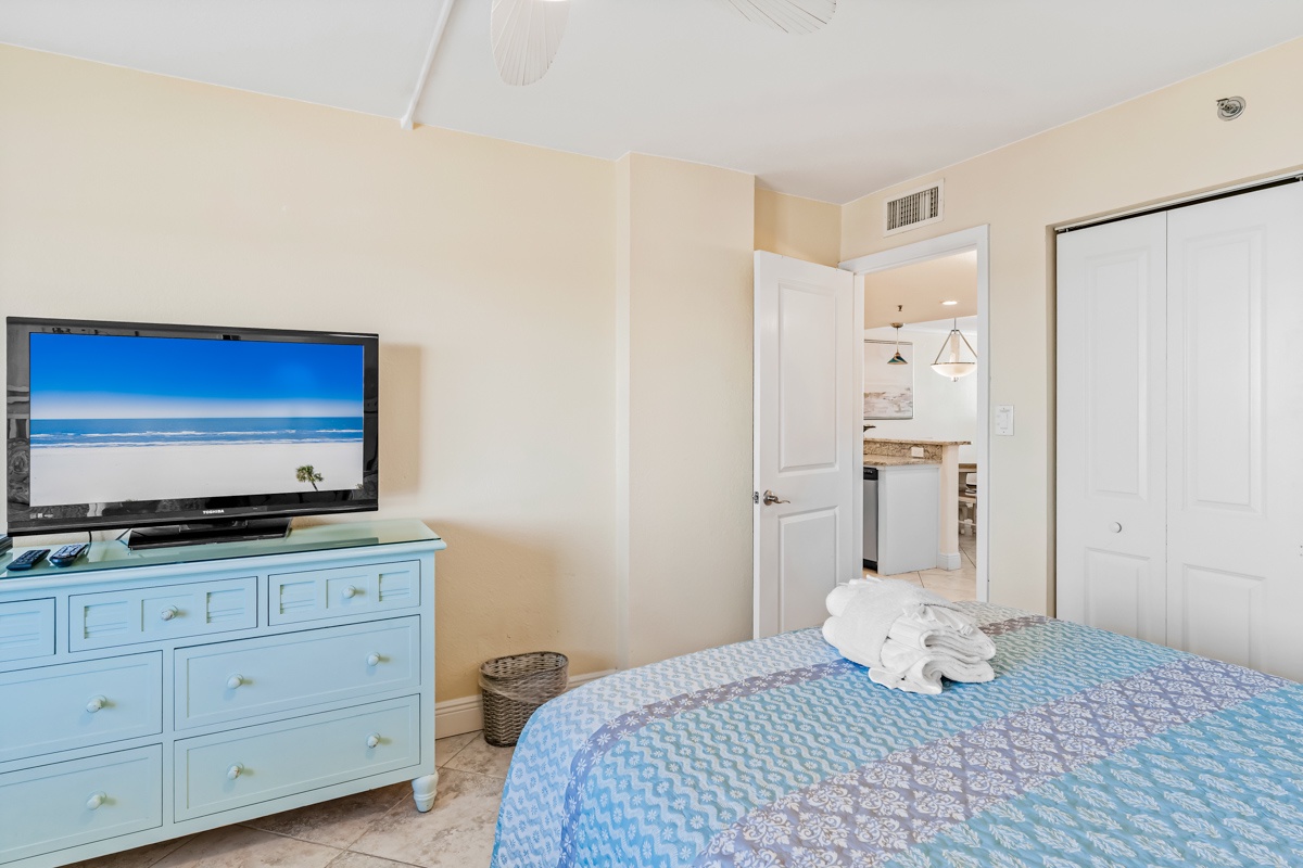 Your peaceful bedroom features coastal-blue furnishings, flat-screen TV, and air conditioning for ultimate comfort after beach days.