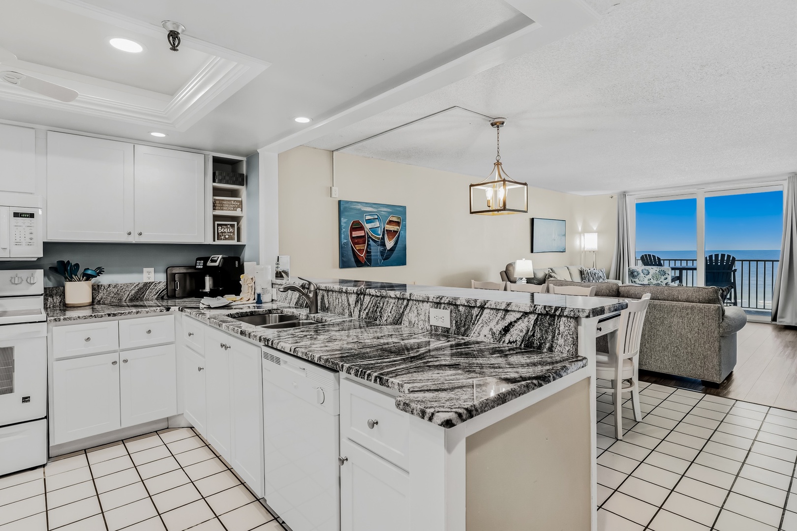 Prepare your favorite meals on elegant granite countertops while soaking in stunning ocean views through floor-to-ceiling windows. The spacious kitchen flows seamlessly into your living area, perfect for entertaining.