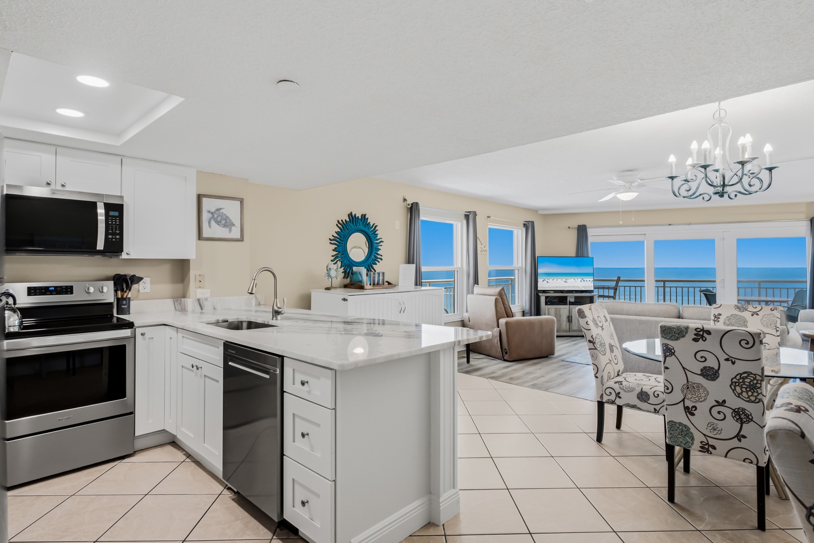 Step into your bright, open kitchen with gleaming granite counters and stainless appliances, where panoramic ocean views through floor-to-ceiling windows make every moment unforgettable.