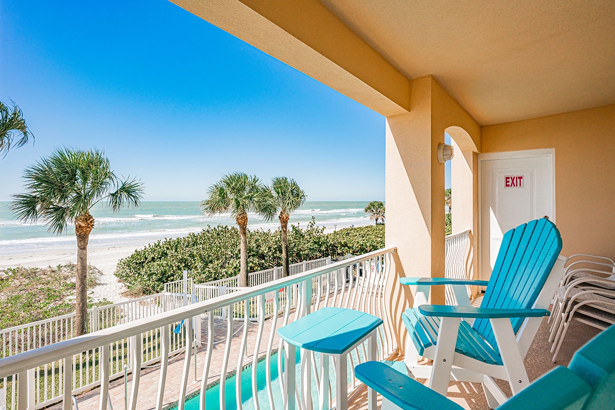 Relax on your private balcony with turquoise chairs while soaking in stunning ocean views and gentle sea breezes.