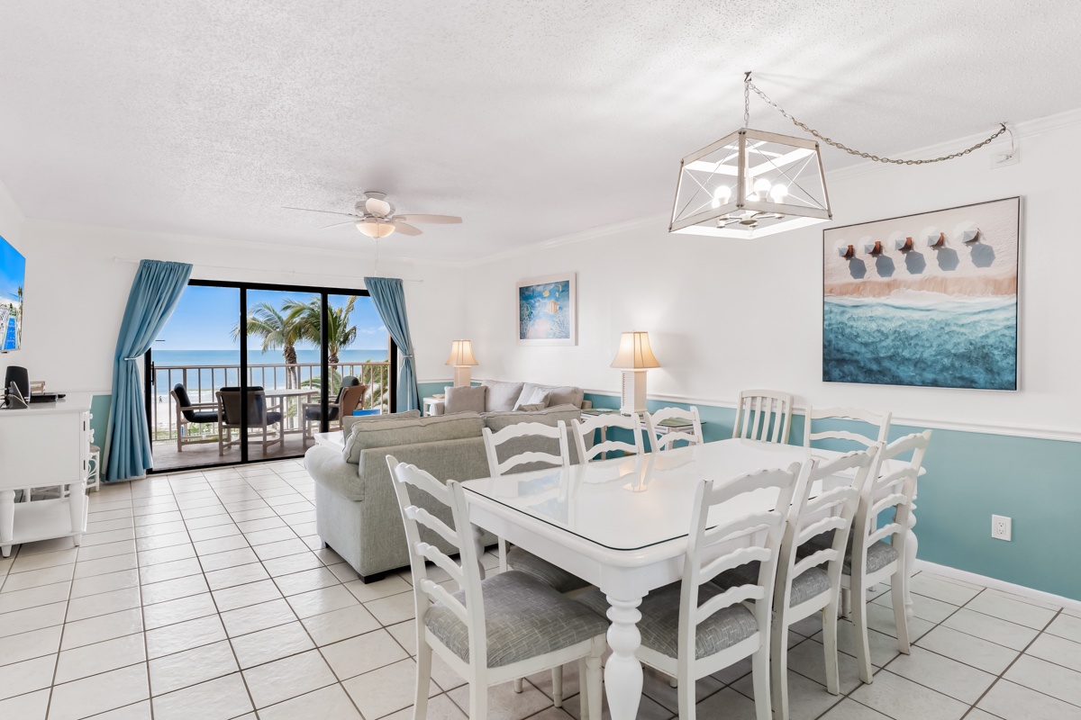 Your bright coastal dining space flows into a cozy living area, where palm trees frame stunning ocean views from your private balcony.