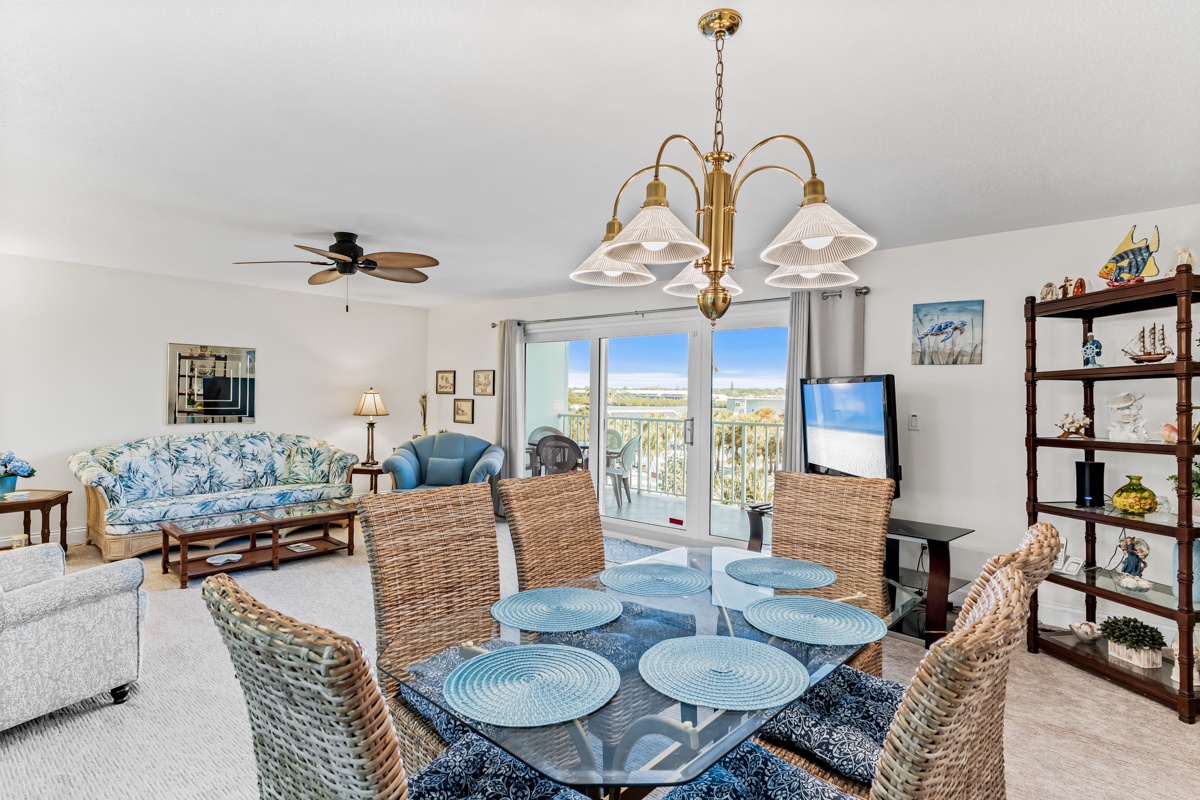 Unwind in your elegant living space with coastal charm, featuring a glass dining table and comfortable seating perfect for memorable meals.