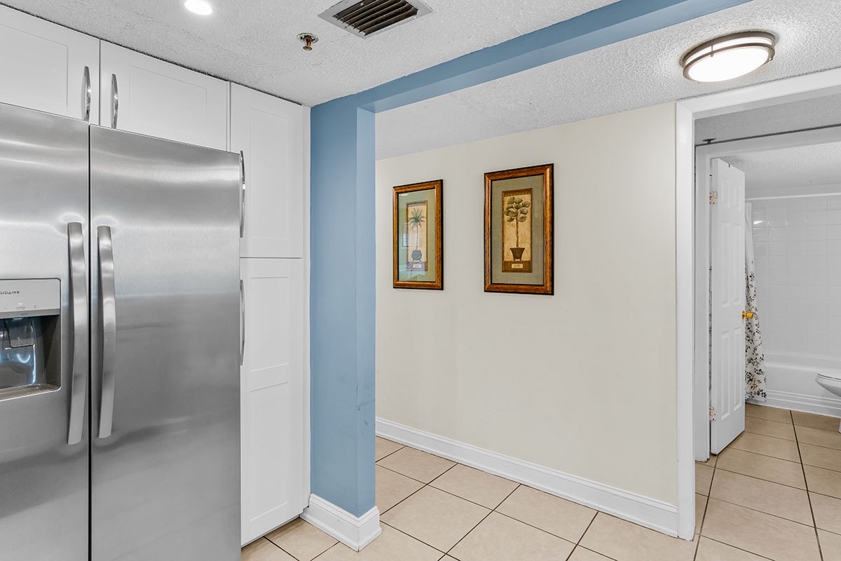 Your spacious kitchen awaits with gleaming stainless steel appliances and crisp white cabinetry, perfect for preparing meals during your stay.