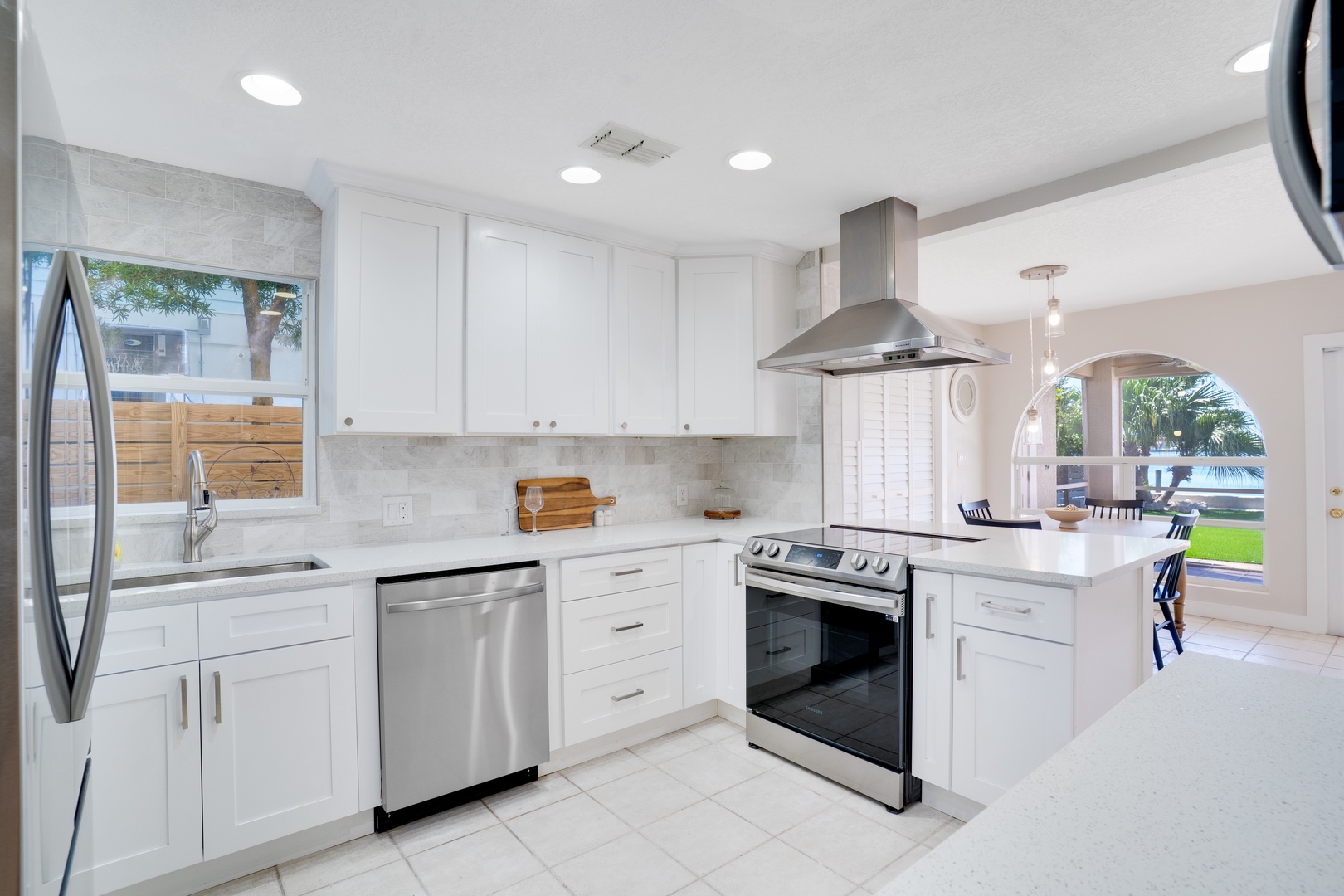Your sleek kitchen features modern stainless steel appliances, pristine white countertops, and ample prep space for creating memorable vacation meals together.