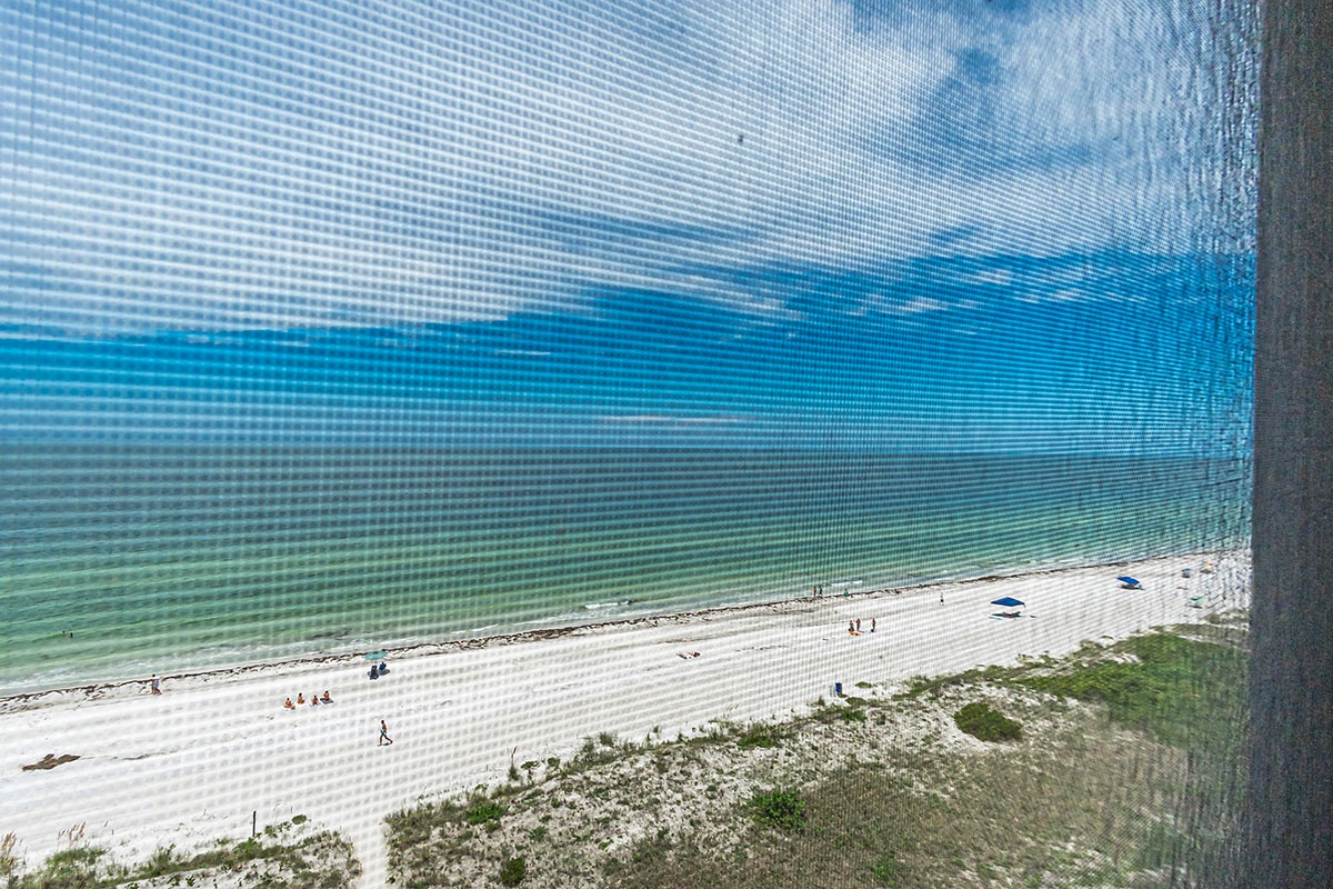 Stunning beachfront view through your window reveals pristine white sand and crystal-clear turquoise waters stretching endlessly before you.