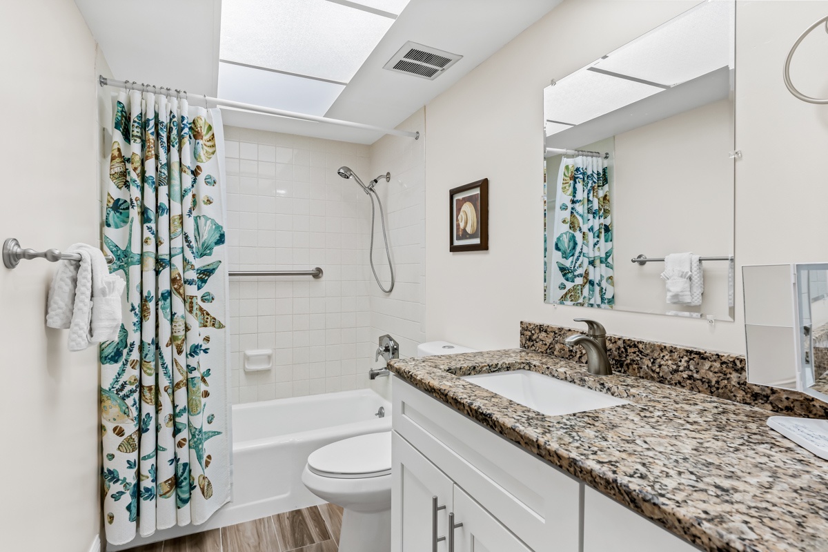 Your stylish bathroom features granite counters, a rainfall shower, and tropical touches that make your morning routine feel refreshing.