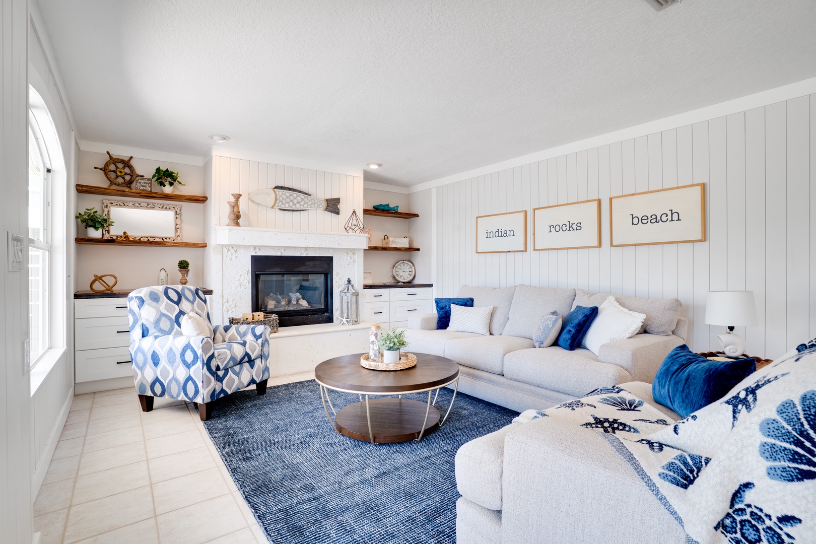 Sink into your coastal living room where nautical charm meets modern comfort, complete with fireplace and ocean-inspired decor for perfect relaxation.