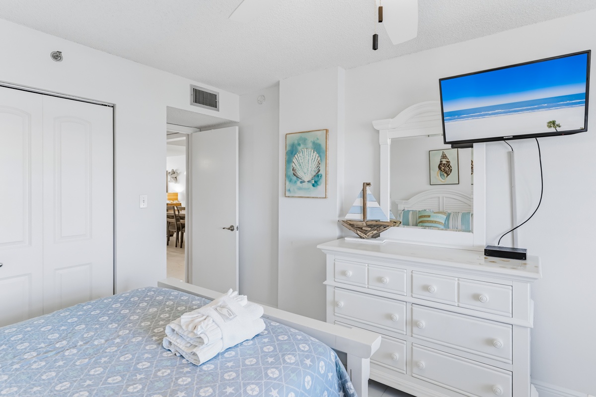 Drift off to sleep in this bright coastal bedroom with fresh linens, entertainment, and soothing ocean-inspired décor surrounding you.