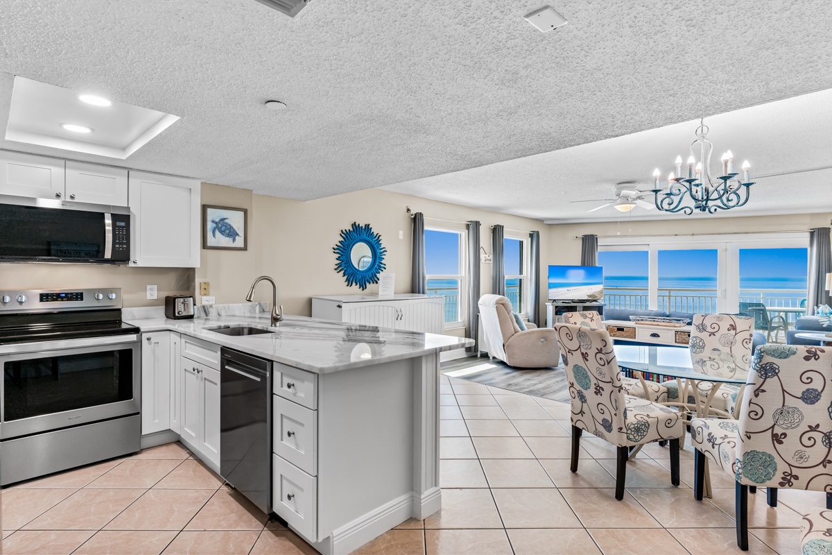 Your beachfront kitchen flows seamlessly into the living space, where panoramic ocean views create the perfect backdrop for memorable meals.