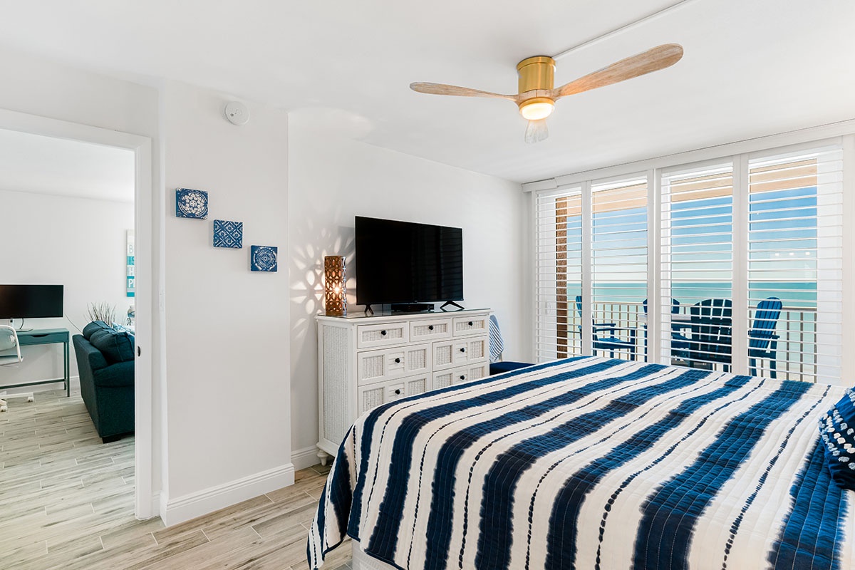 Wake up to ocean views through your private balcony doors, with coastal blues and whites creating a peaceful retreat for restful nights.