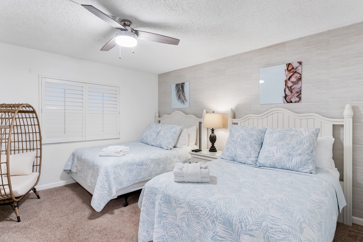 Slip into your coastal retreat where soft linens and peaceful tones invite you to unwind. The gentle ceiling fan and cozy furnishings promise restful nights by the shore.