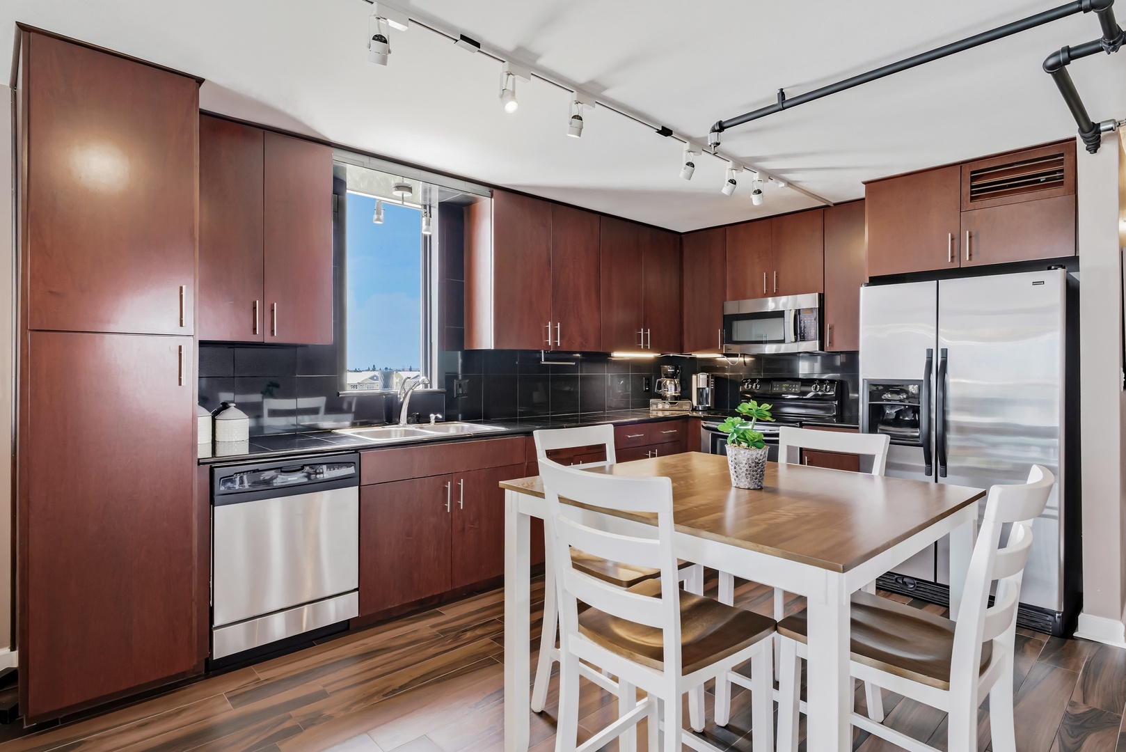 Cook your favorite meals in this modern kitchen, featuring sleek cabinetry, stainless steel appliances, and a cozy dining table perfect for your morning coffee or shared dinners.