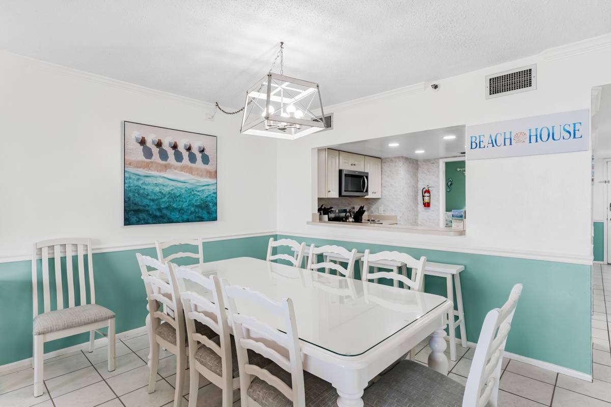 Gather your group around this spacious dining table where beach-themed décor creates a refreshing coastal atmosphere for memorable meals together.