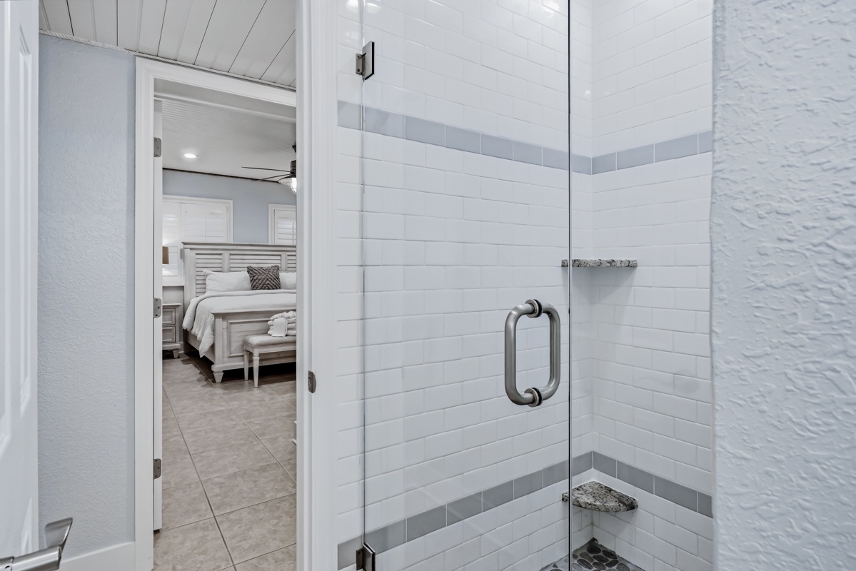 Step into your pristine glass-enclosed shower with elegant subway tiles and spa-like finishes for a refreshing start to each day.