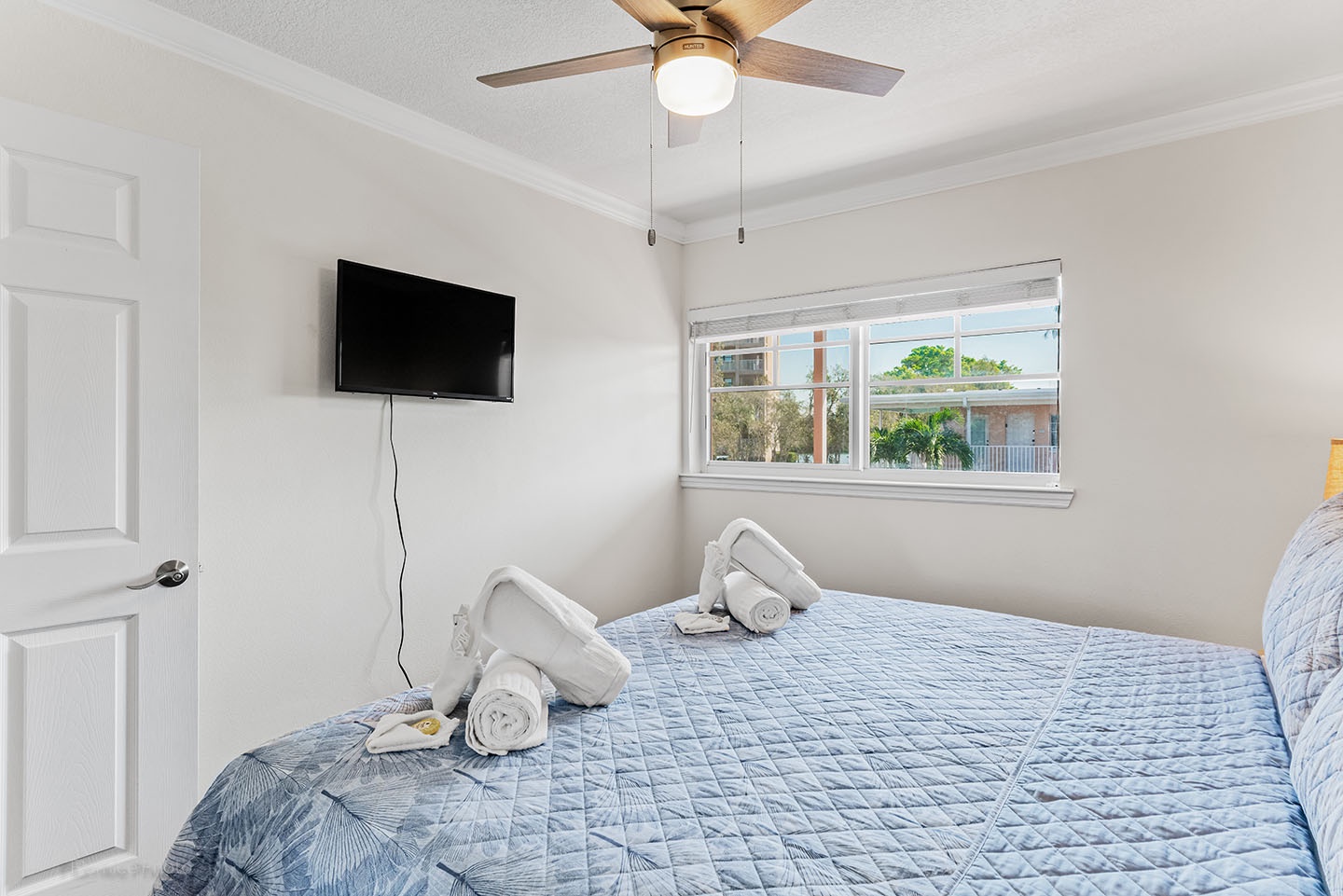 Master bedroom with smart TV and ceiling fan