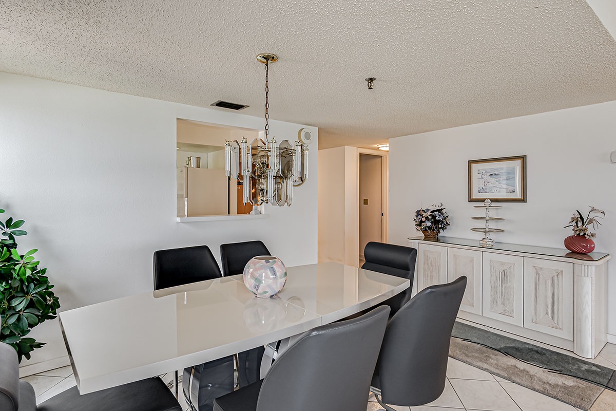 Your elegant dining space features a gleaming white table with comfortable seating for six, perfect for memorable meals together.