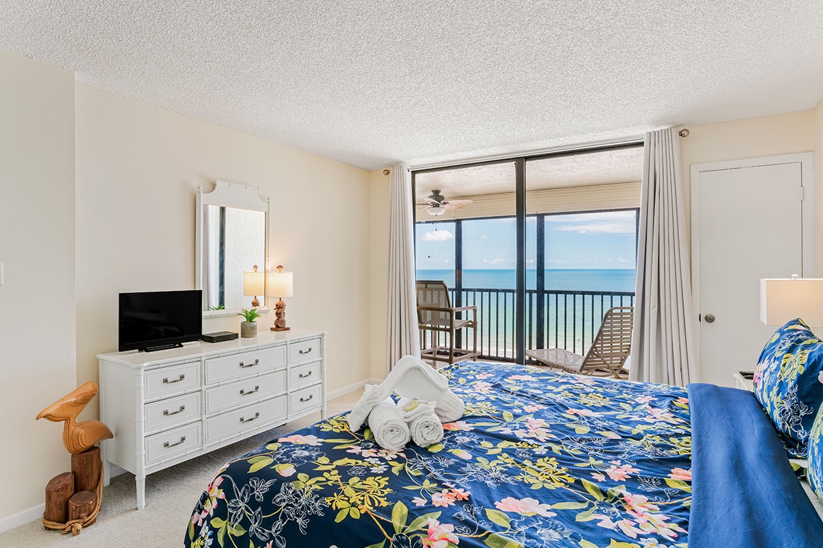 Wake up to breathtaking ocean views from your coastal bedroom, where tropical-themed bedding and private balcony create your perfect seaside retreat.