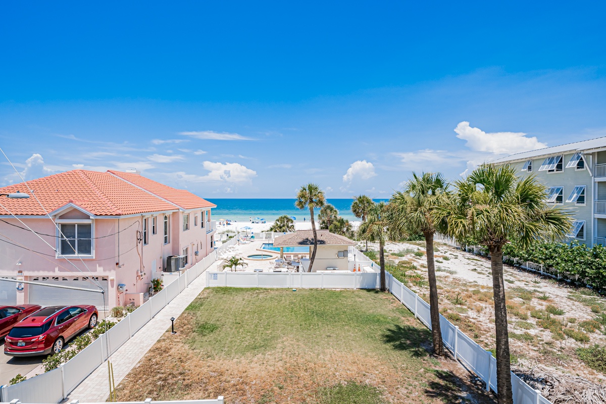 This beachfront property features a private pool area and lush palm trees, with direct access to pristine white sand beaches and turquoise waters just steps away.