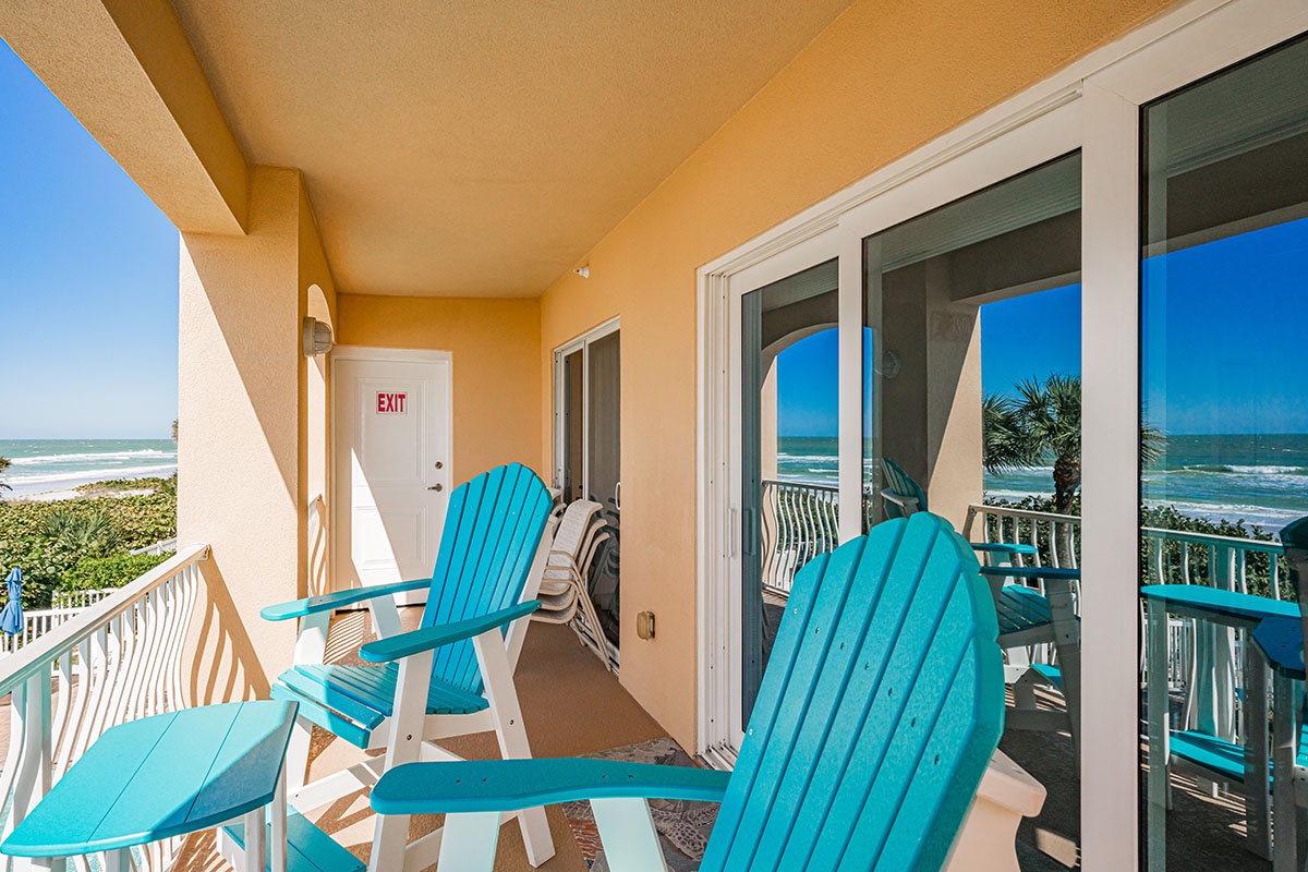 Your private balcony oasis awaits with turquoise Adirondack chairs perfectly positioned for morning coffee and ocean views.