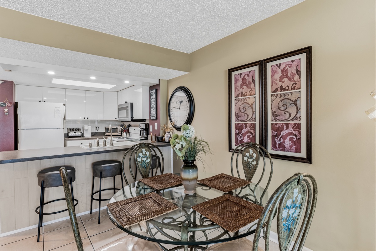 Picture yourself gathering around this inviting dining table, perfectly positioned for meals while staying connected to the bright kitchen. The elegant decor and open layout create a welcoming space for your vacation memories.