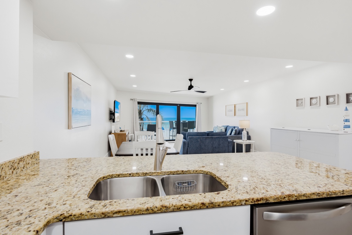 Your open-concept kitchen flows seamlessly into the living area, where azure ocean views create a stunning backdrop for your stay.