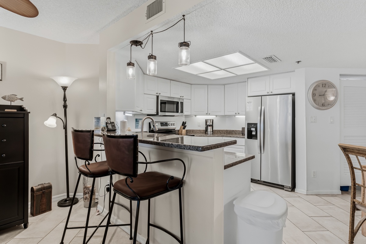 Your modern kitchen awaits with crisp white cabinetry, granite countertops, and stainless steel appliances—ready for you to whip up your favorite meals or morning coffee.