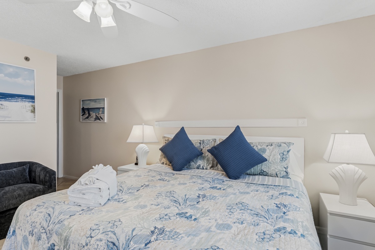 Sink into crisp linens and plump pillows in this serene coastal-inspired bedroom, where soft blue accents and gentle lighting create your perfect retreat after a day of exploring.