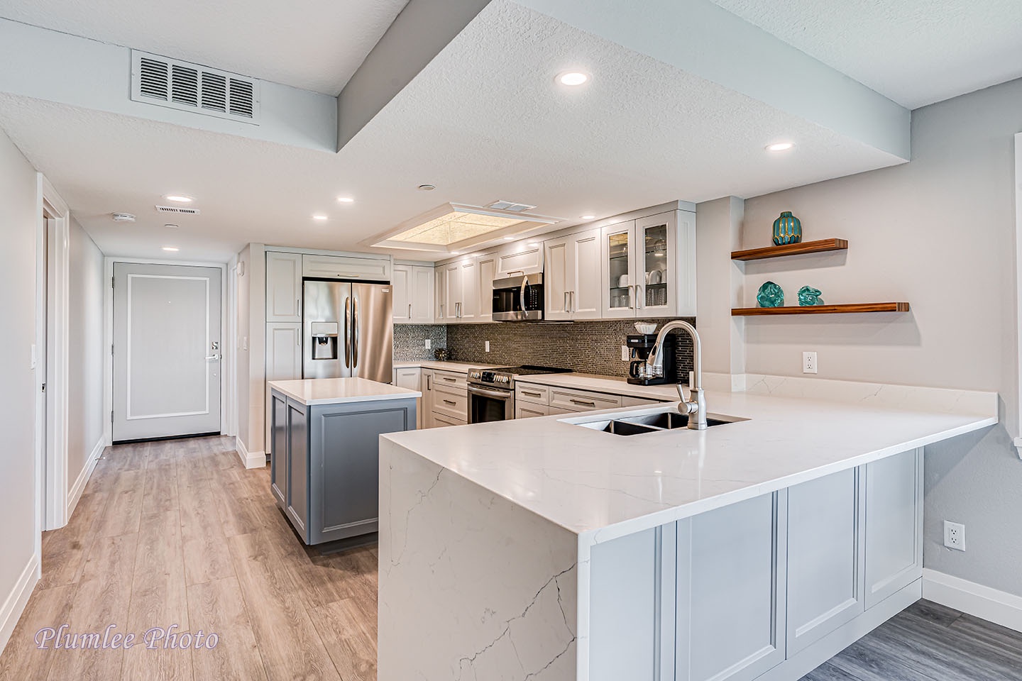 Wide quartz counter tops and stainless appliances.