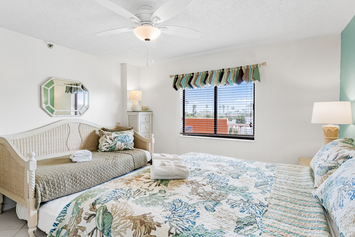 Your bright bedroom features coastal-inspired linens and a cozy daybed, perfect for relaxing after beach days.