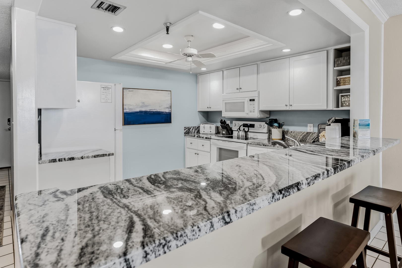 Your fully equipped kitchen features stunning granite countertops and bright white cabinetry, perfect for preparing meals together or sipping morning coffee at the breakfast bar.