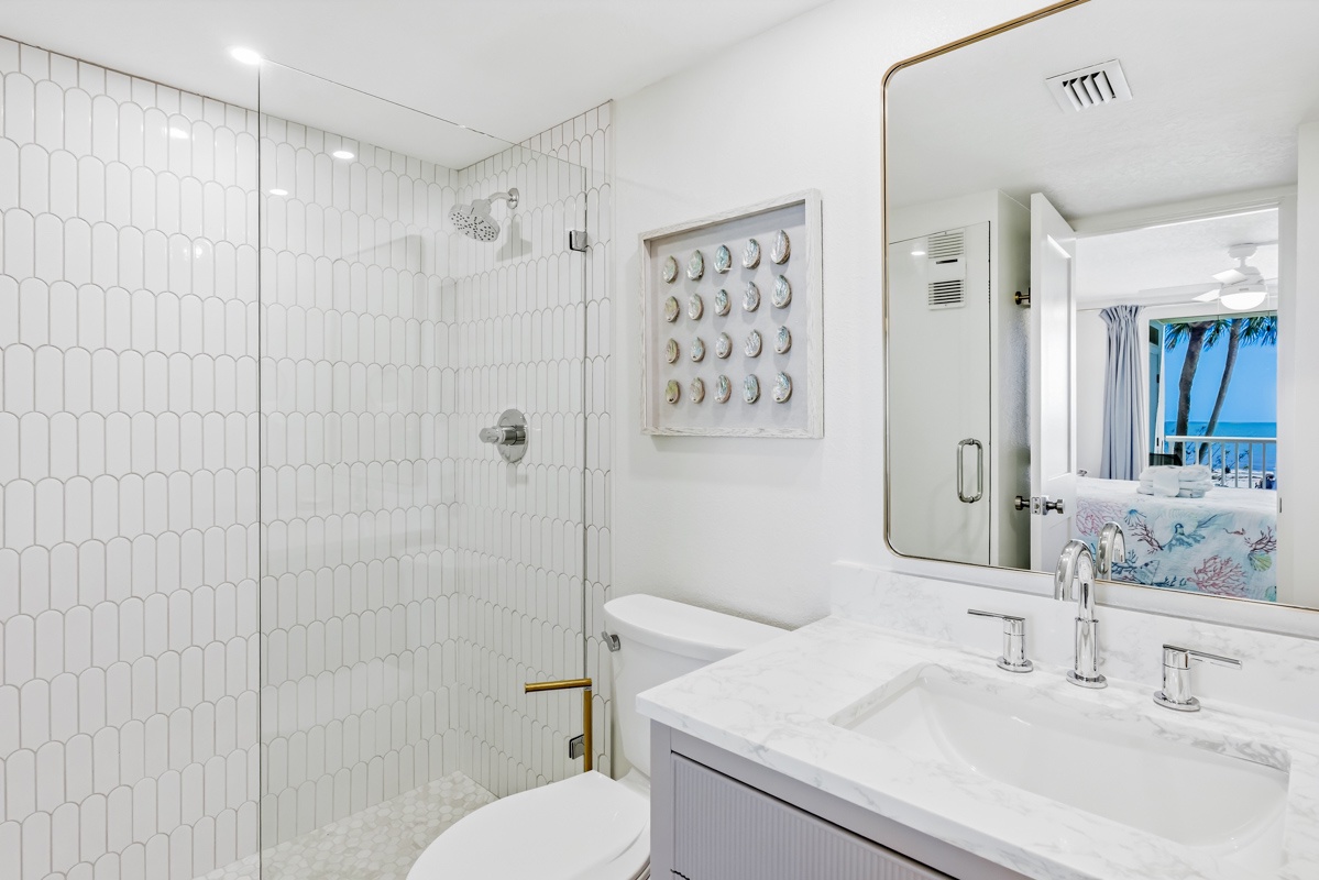 Luxurious marble bathroom with stylish hex-tile shower and ocean glimpses for your perfect getaway retreat.