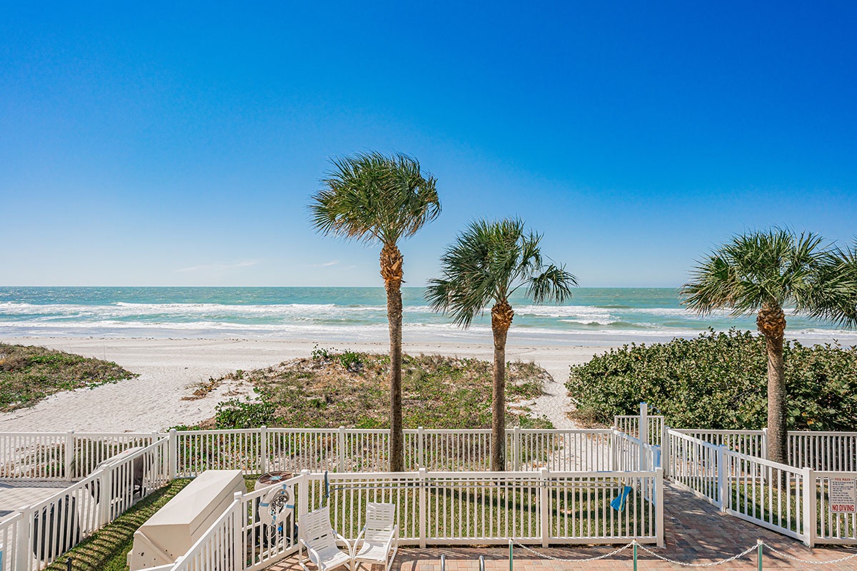 Direct beachfront access with pristine white sand, swaying palms, and turquoise waters just steps from this tropical paradise property.