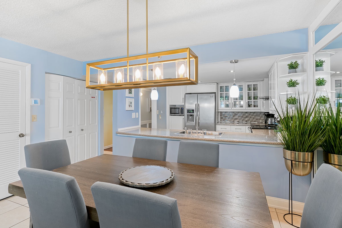 Gather around the generous dining table, where the open-concept design lets you stay connected while meals are prepared in the bright, fully-equipped kitchen just steps away.