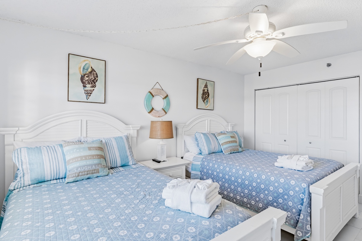 Your coastal-themed bedroom features queen beds with soft blue linens and charming nautical touches for a peaceful seaside retreat.