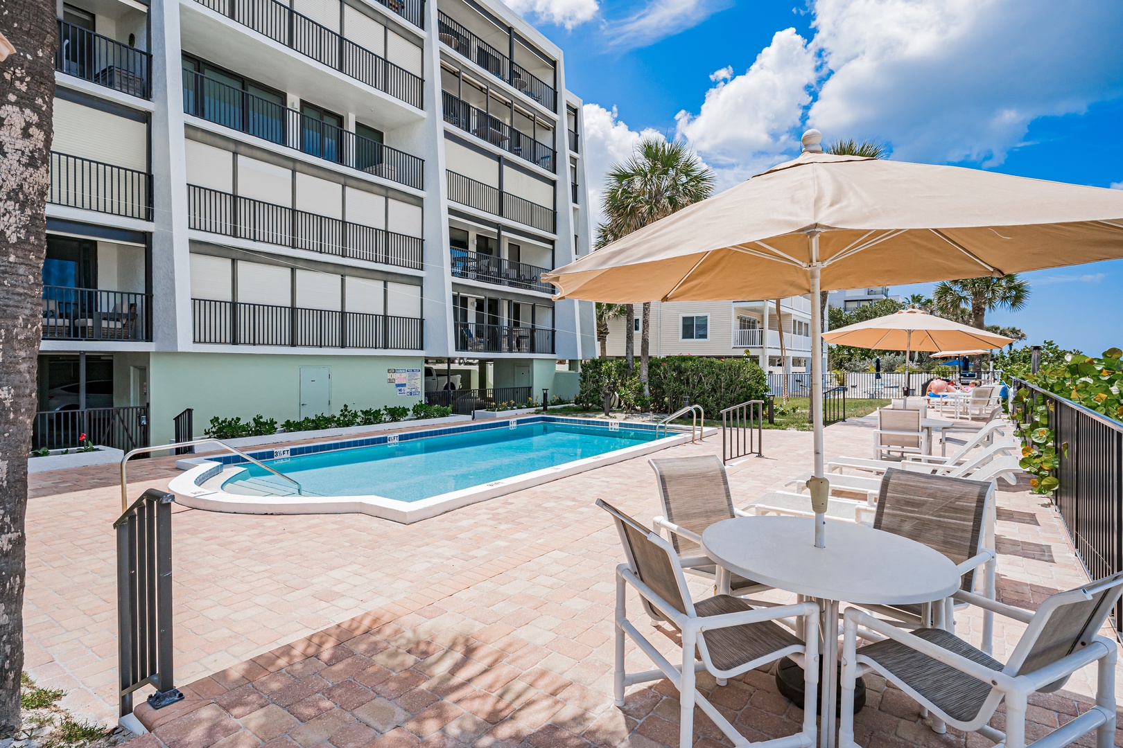 Picture yourself lounging poolside under the Florida sun, sipping cool drinks at your private table, surrounded by swaying palms. Your bright, modern retreat awaits just steps away.