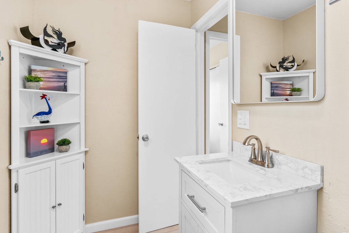 Your private bathroom features marble countertops, modern fixtures, and thoughtful storage with coastal-inspired décor creating a serene retreat.