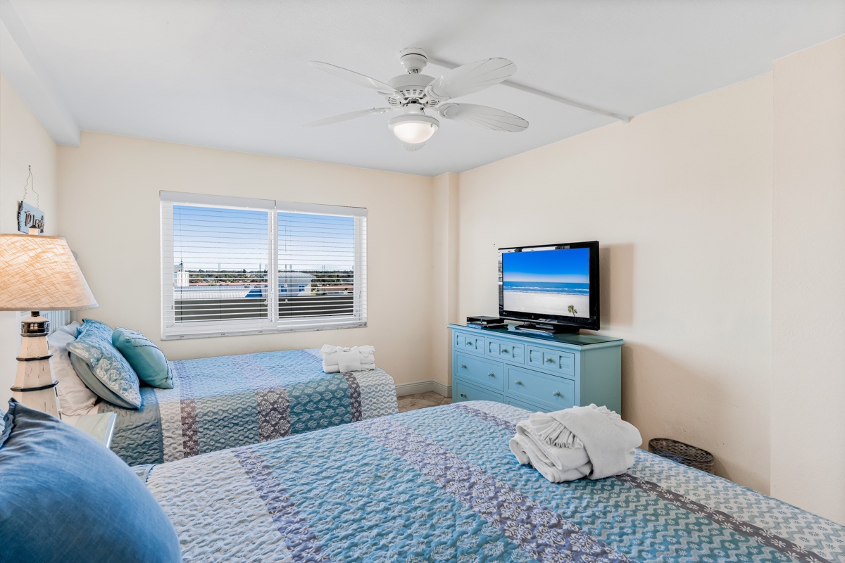 Drift off in your coastal twin bedroom, where ocean breezes from the ceiling fan and beach views on TV create your perfect seaside sanctuary.