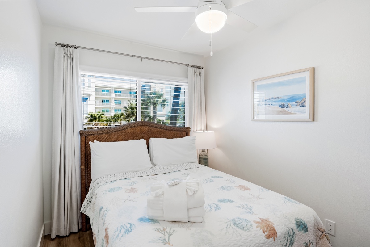 Rest peacefully in your cozy bedroom with natural light streaming through large windows and fresh towels awaiting your arrival.