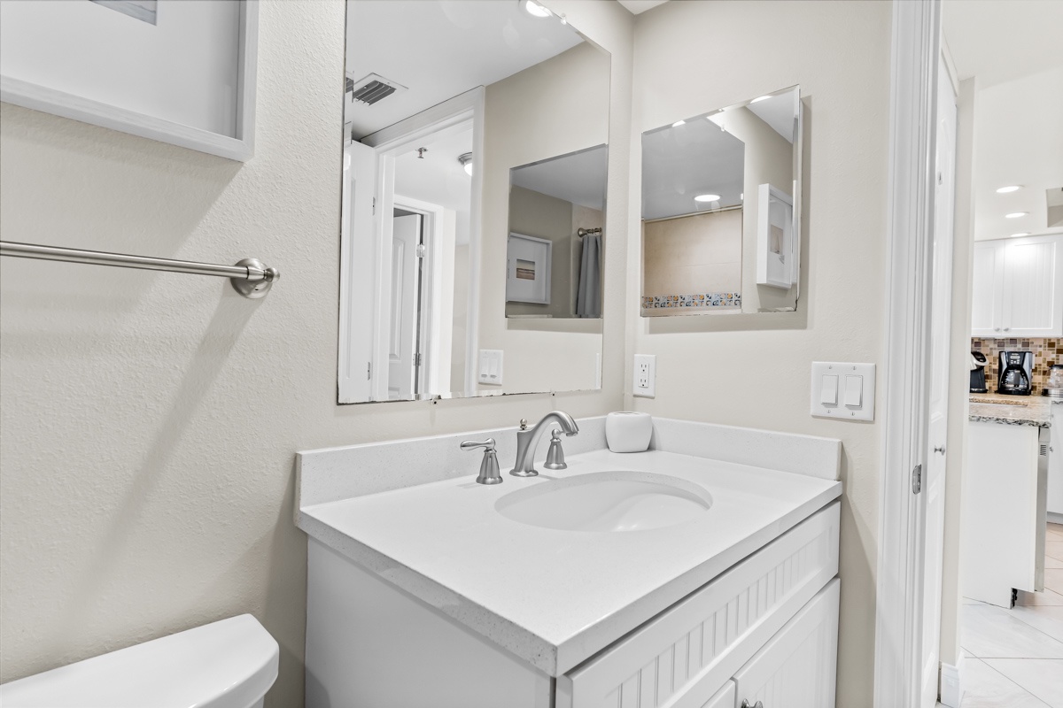 Your pristine bathroom features elegant white cabinetry, marble countertops, and thoughtful amenities for a refreshing start to each day.