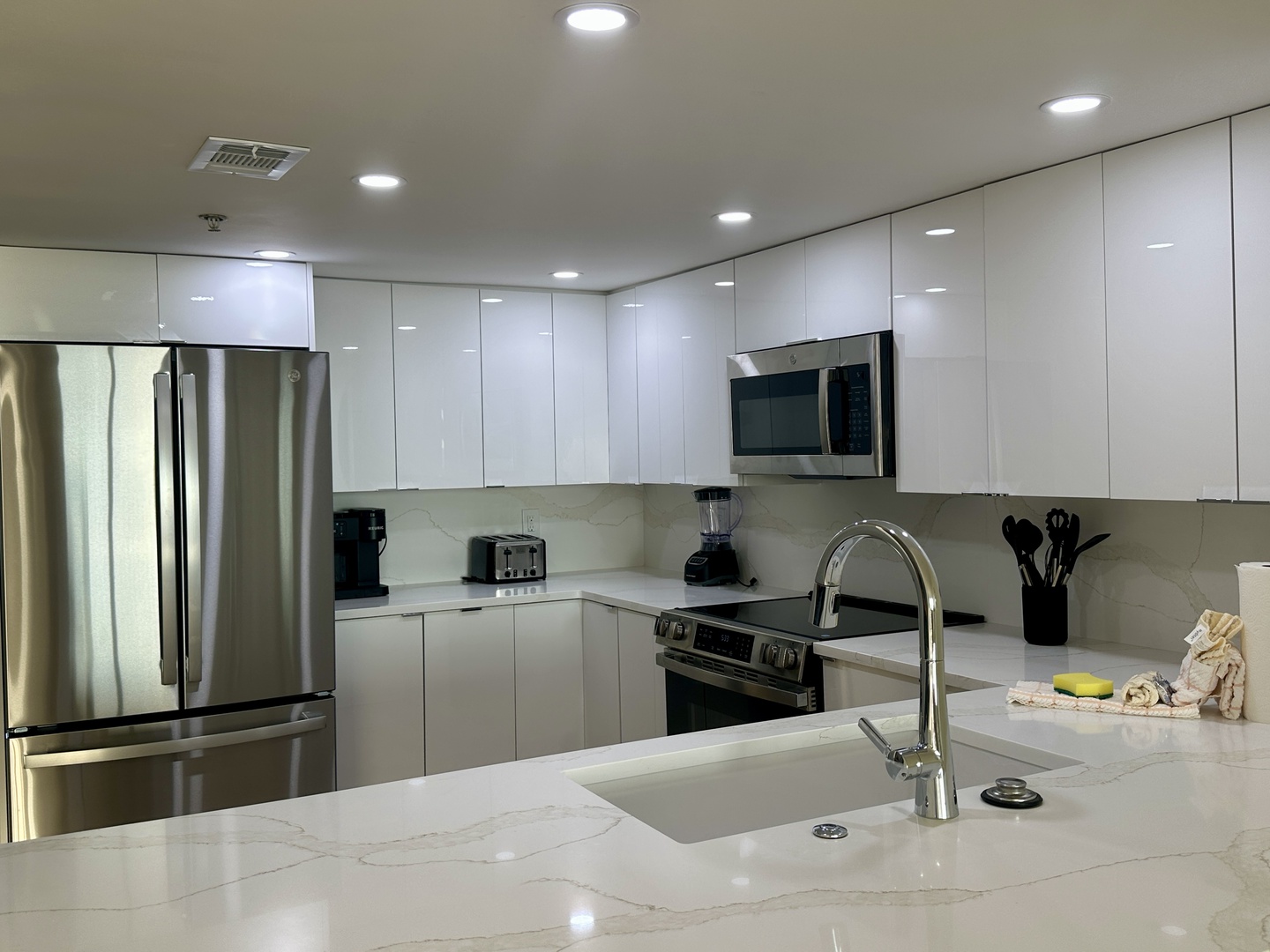 Your sleek modern kitchen features premium stainless steel appliances, gleaming white cabinets, and gorgeous marble countertops perfect for preparing memorable meals.