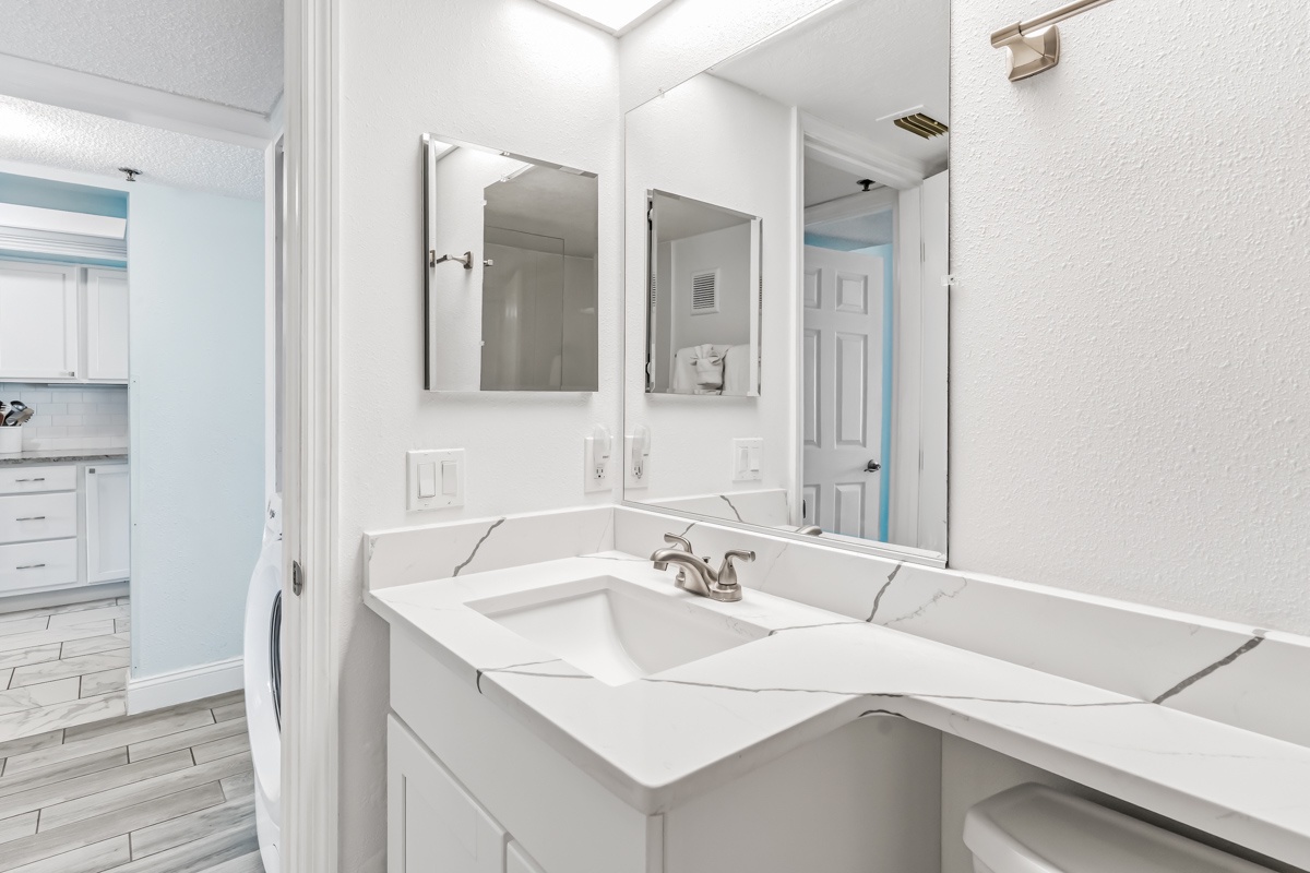 Step into your bright, pristine bathroom with dual sinks and ample counter space for all your essentials. The fresh, modern design and generous vanity make your morning routine effortless.