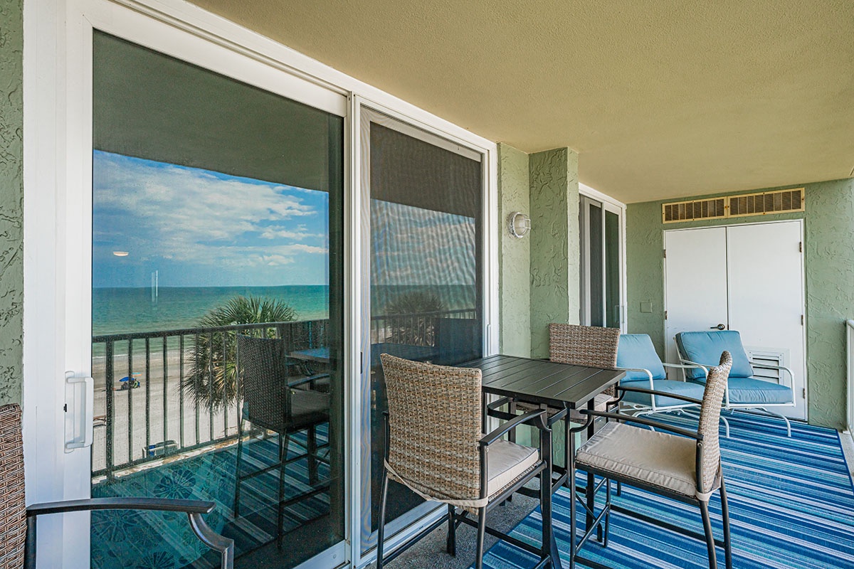 Your private balcony dining area features ocean views and comfortable seating for memorable beachfront meals.