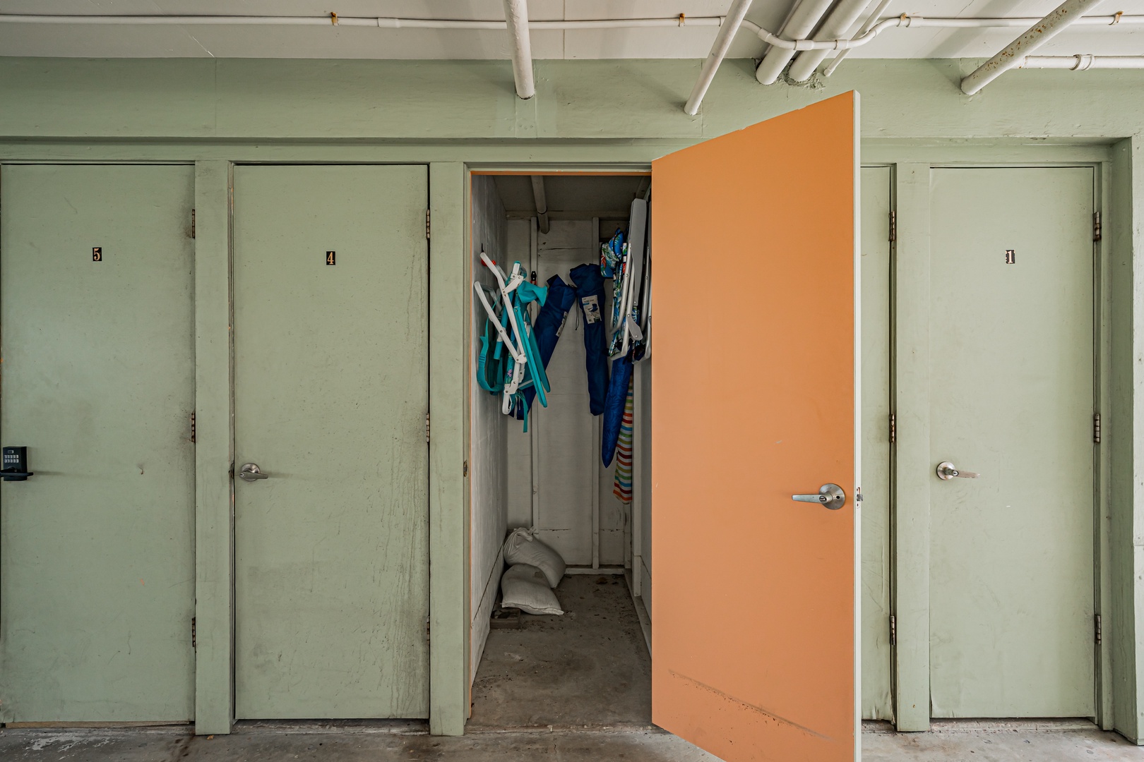 Storage lockers line the hallway, with one open to reveal beach gear and towels—perfect for stashing your sandy treasures after a day by the water.