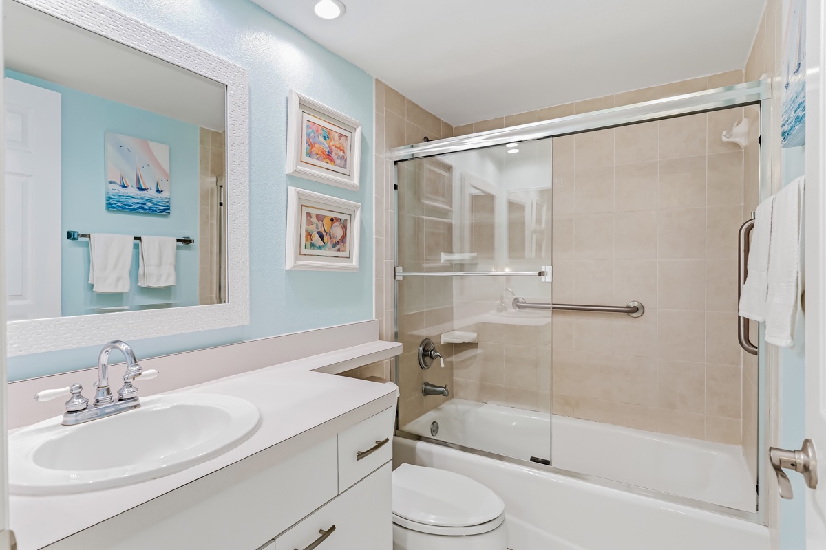 Refresh after your beach adventures in this bright, coastal-inspired bathroom. You'll find a full tub-shower combo, plenty of counter space, and soft linens waiting for you.