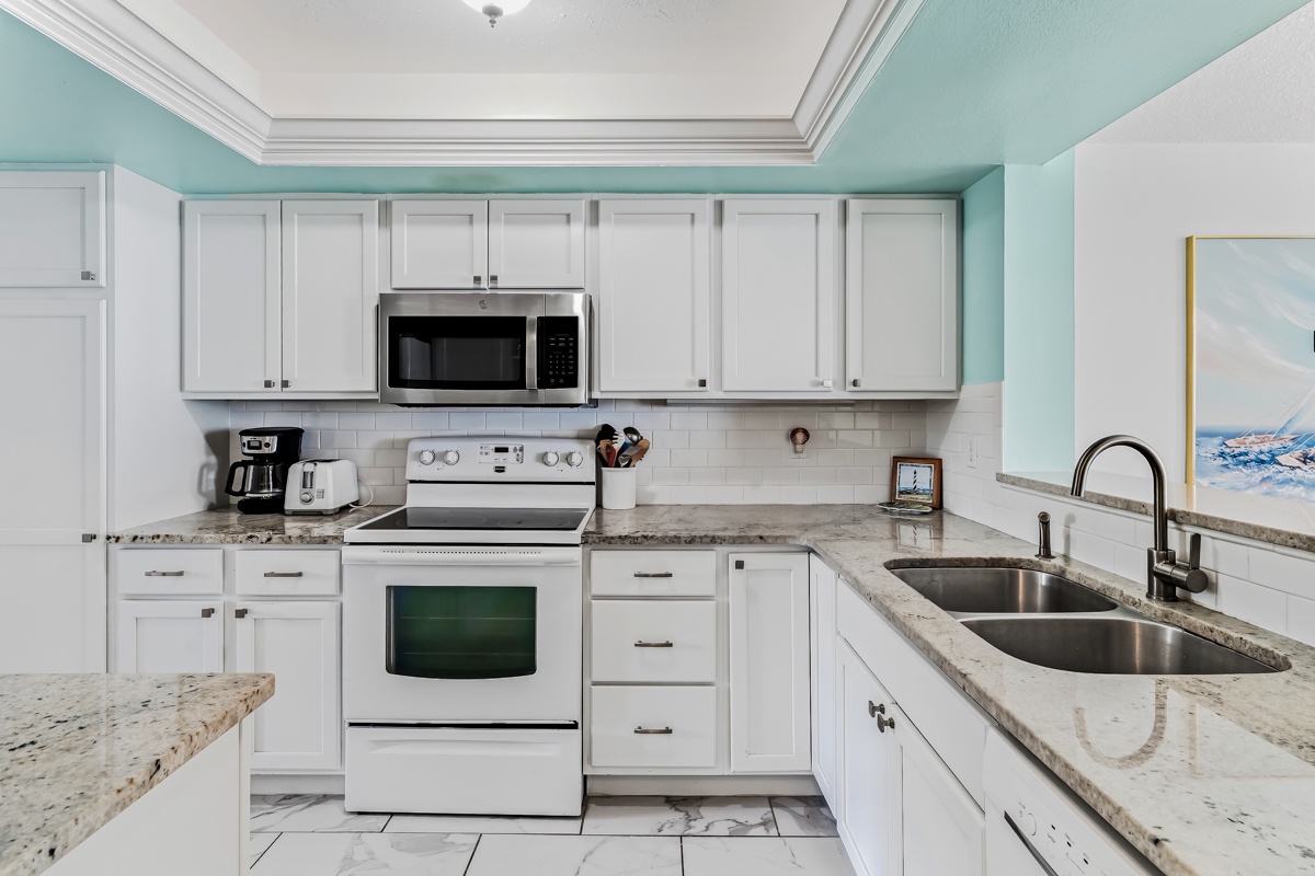 Your fully equipped kitchen awaits, complete with modern appliances, plenty of counter space, and cheerful coastal tones that make meal prep feel like a breeze.