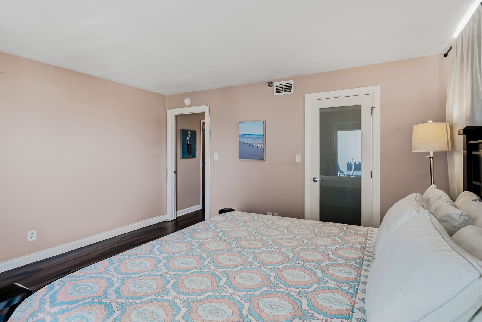 Sink into soft linens and unwind in your peaceful coastal-themed bedroom, with gentle hues and beach-inspired artwork setting a tranquil mood for restful nights.